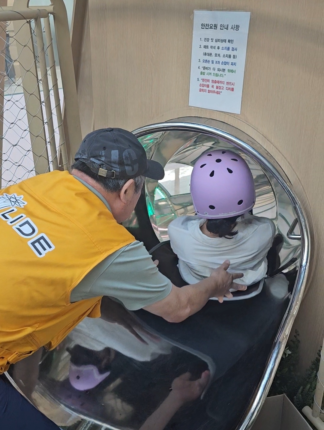 A safety guard helps a visitor get into position for a safe ride. (Choi Jae-hee / The Korea Herald)