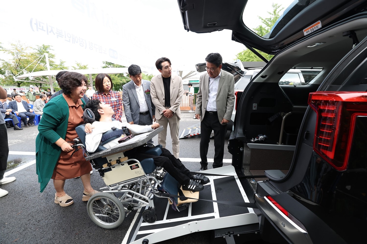 보조기기가 설치된 차량에 휠체어에 탄 아들을 태우고 있는 김혜경씨. [노원구 제공]