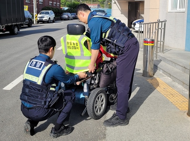 토토사이트 더베이 완도경찰서 직원들이 어르신들이 운전하는 전동차 좌석에 야광 조끼를 끼워주며 추돌 사고 예방에 나서고 있다.  [사진 토토사이트 더베이경찰]
