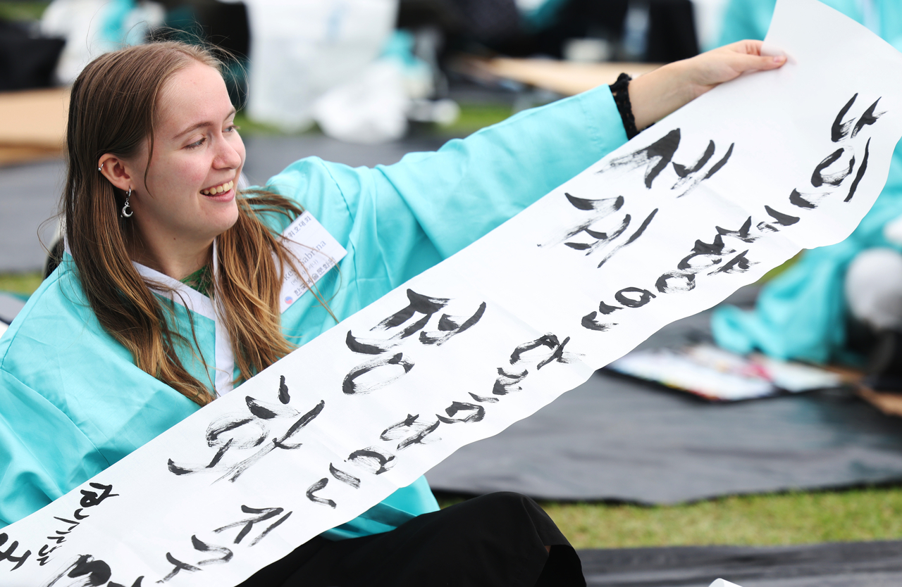 A participant holds up her Hangeul calligraphy that reads “world peace,” at the 16th annual Gwanghwamun Square Calligraphy Competition in Gwanghwamun Square, central Seoul, Thursday. (Yonhap)