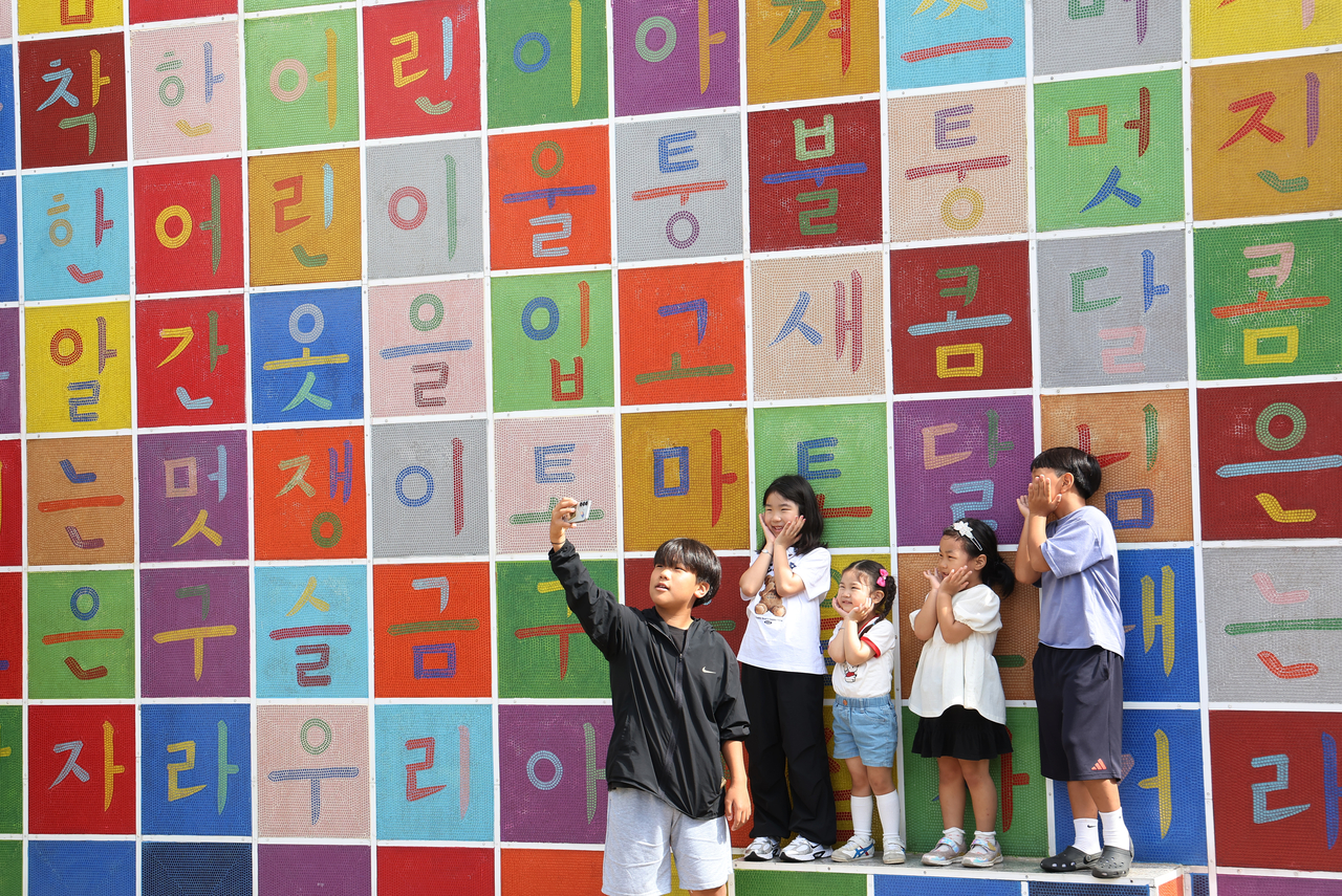 Children take photos in front of a Hangeul-themed mural on Wednesday at Gyeonggi Children's Museum in Yongin, Gyeonggi Province. (Yonhap)