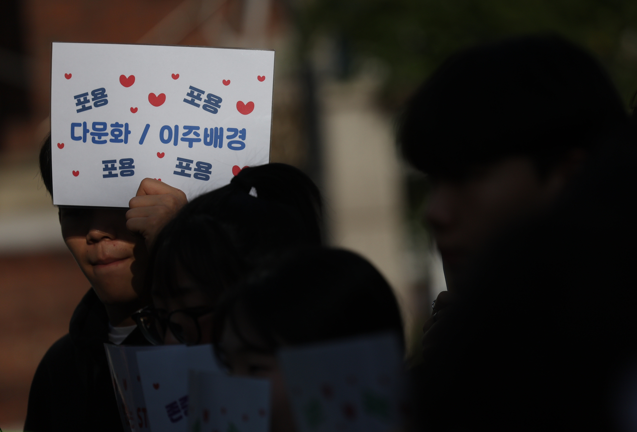 Middle school students in Guro-gu, Seoul, hold a sign to stop Sinophobia, in this Sept. 25 photo. The word "tolerance" is written four times around the words "multicultural" and "immigrants." (Yonhap)