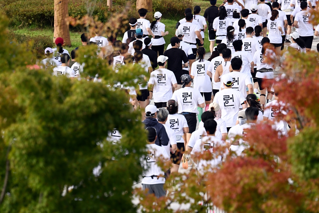 Participants in the 2025 Hangeul Run jog through Sejong Lake Park on Thursday amid mild autumn weather. (Park Hae-mook/The Korea Herald)