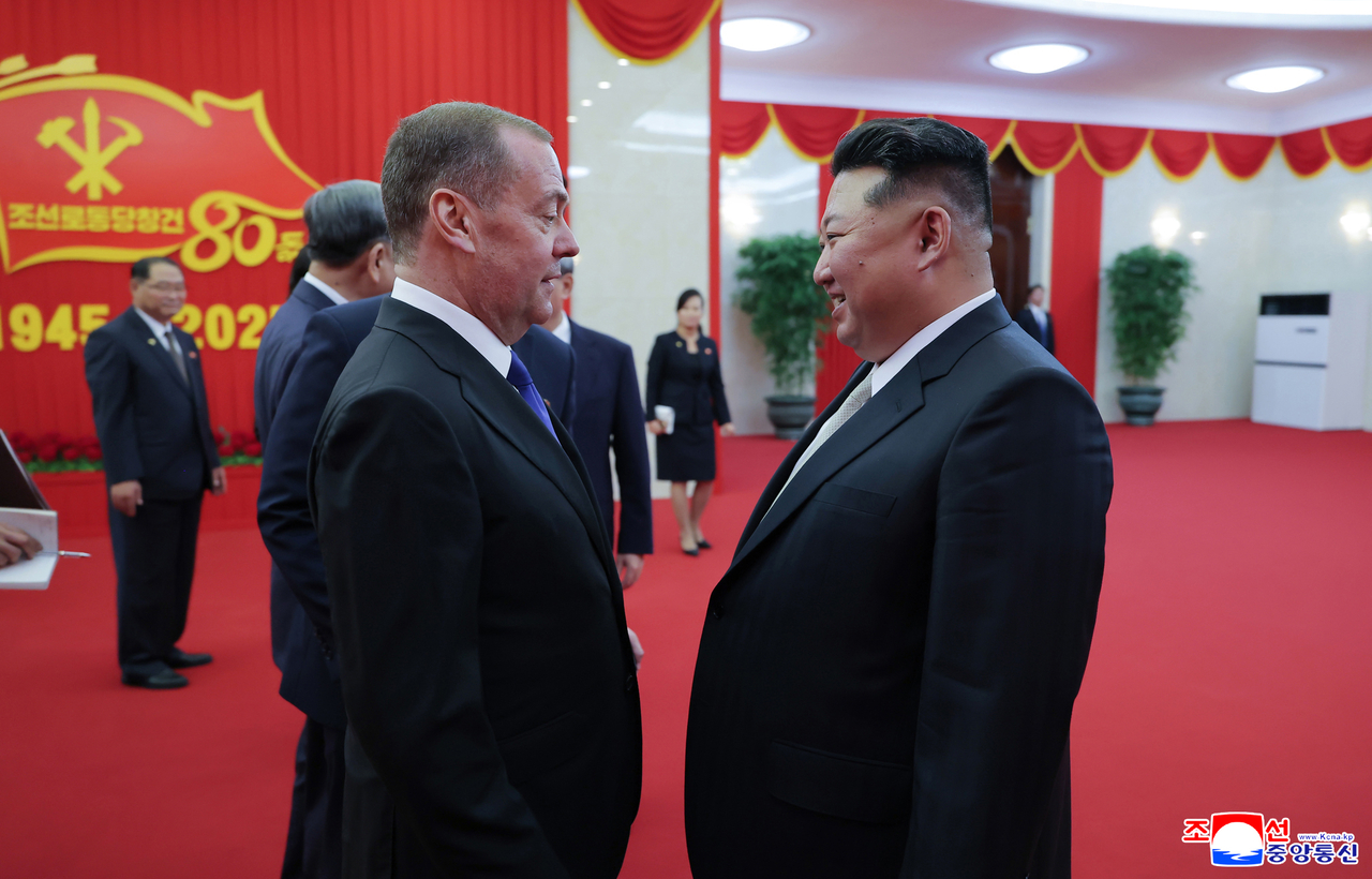 The North's leader Kim Jong-un (right) speaks with Dmitry Medvedev, deputy chairman of the Russian Security Council, at a stadium in Pyongyang, where celebrations for the 80th anniversary of the founding of the ruling Workers' Party of Korea were being held, on Thursday, in this photo carried by North Korea's official Korean Central News Agency the next day. (Yonhap)