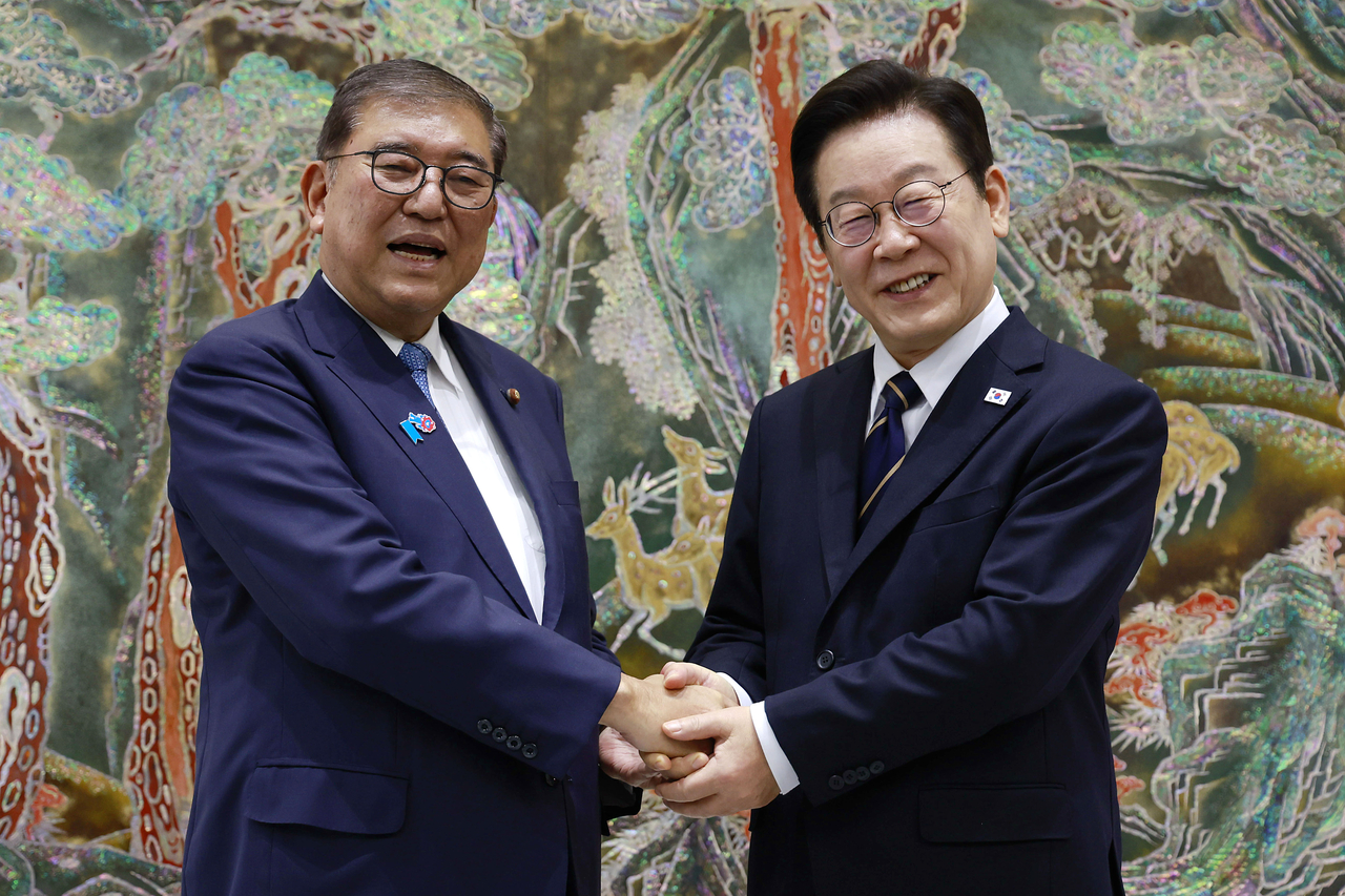 President Lee Jae Myung (right) and Japanese Prime Minister Shigeru Ishiba pose for a photo as they meet in Busan, about 320 kilometers southeast of Seoul, on Sept. 30. (Yonhap)