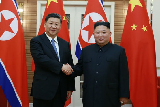 The photo shows Xi Jinping and Kim Jong-un shaking hands during a June 2019 summit in Pyongyang. (Herald DB)