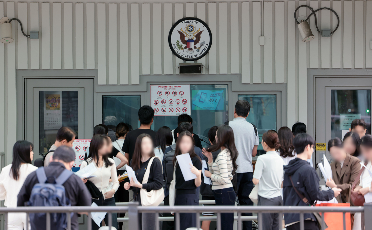 South Koreans line up in front of the US Embassy in central Seoul to wait for visas in September. (Yonhap)