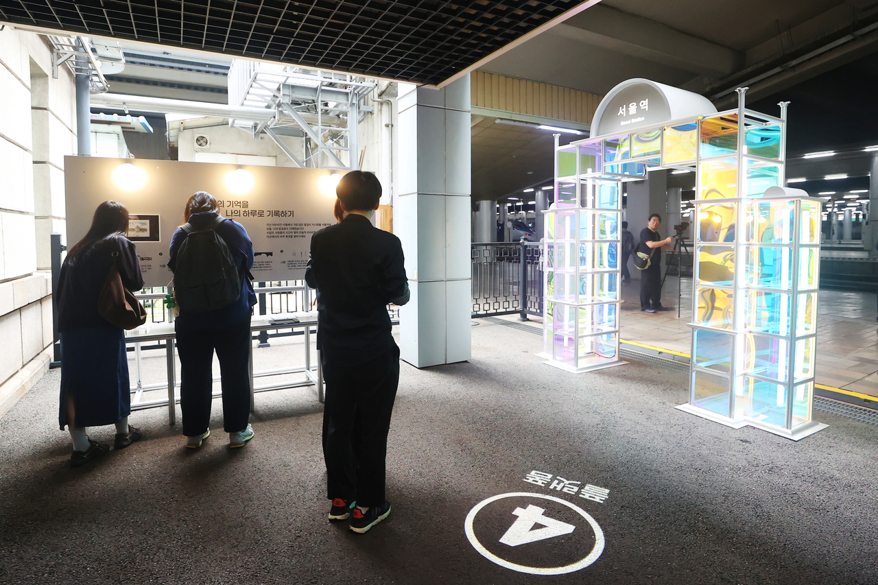 Visitors view a neon arch at the end of a basement hallway at the old Seoul Station, which was revealed to the public for the first time on Tuesday. (Yonhap)