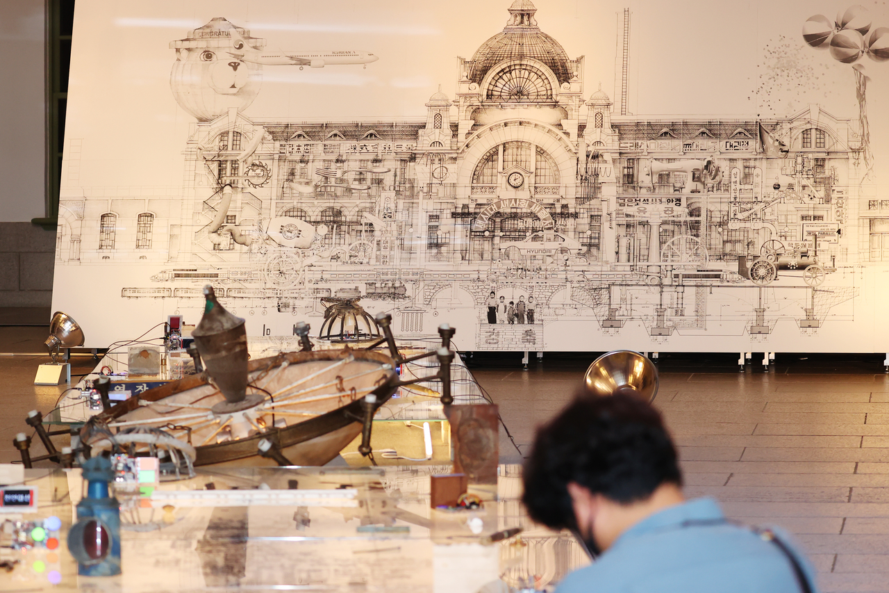 Visitors to the old Seoul Station's centennial exhibition view a floor installation on Tuesday. (Yonhap)