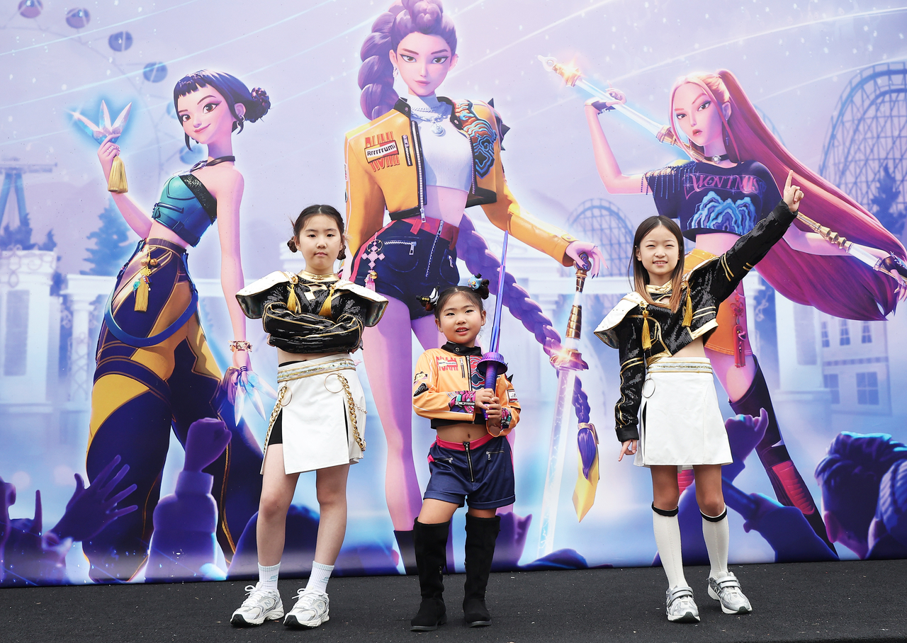 Children pose for a photo in front of a panel with the main characters of "KPop Demon Hunters" at Everland, in Yongin, Gyeonggi Province, on Sept. 30. (Yonhap)