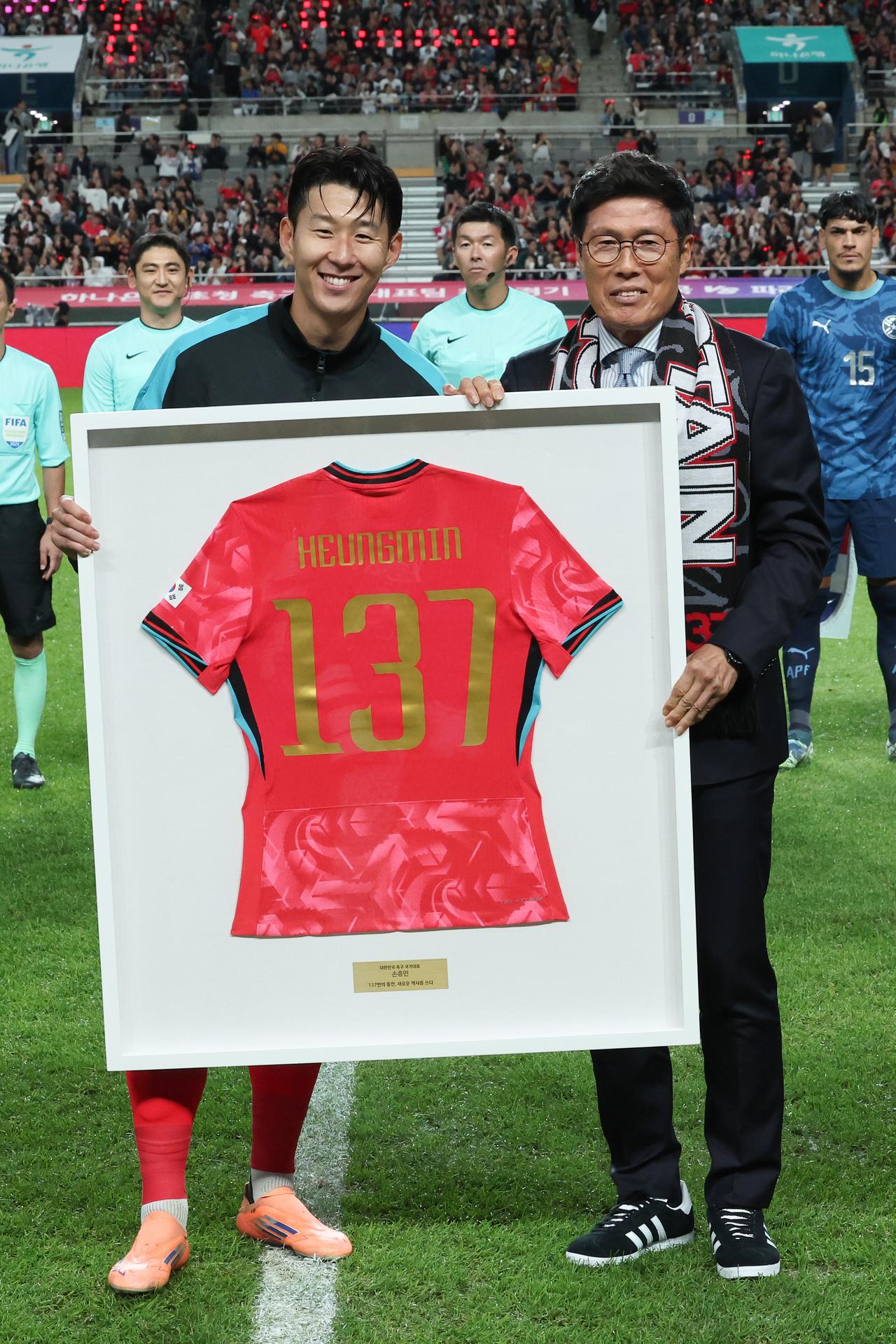 Son Heung-min (left) poses with former striker Cha Bum-kun at Seoul World Cup Stadium in Seoul on Tuesday, during a ceremony recognizing Son's becoming the most-capped male player in South Korean men's football history. (Yonhap)