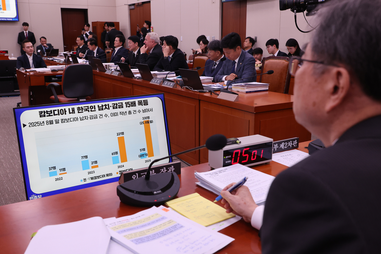 Foreign Minister Cho Hyun (right) listens to a lawmaker's question about crimes targeting South Koreans in Cambodia during an audit by the parliamentary Foreign Affairs Committee at the National Assembly in Seoul on Monday. (Yonhap)
