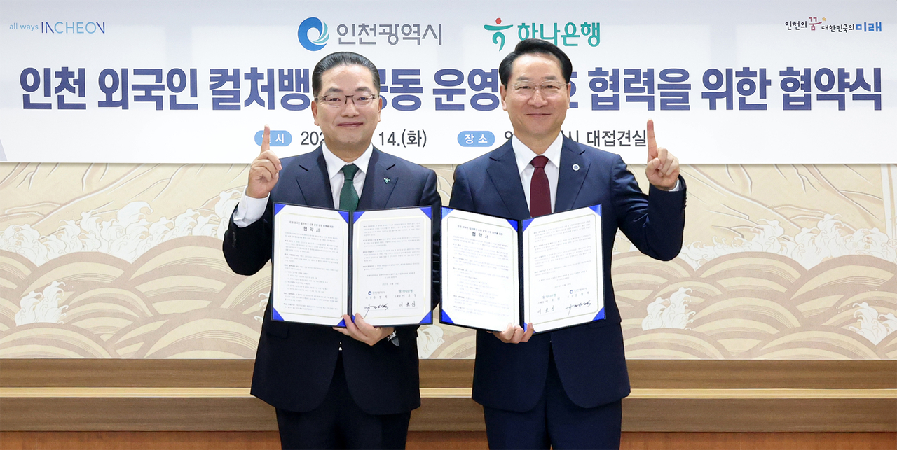 Hana Bank CEO Lee Ho-sung (left) and Incheon Mayor Yoo Jeong-bok pose after signing a memorandum of understanding at the Incheon City Hall in Namdong-gu, Incheon, Tuesday. (Hana Bank)
