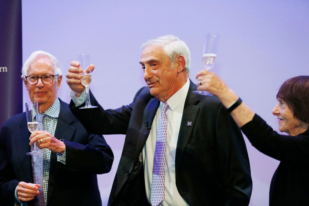 Northwestern Interim President Henry S. Bienen (left), US-Israeli professor Joel Mokyr (center), and his wife, Margalit Mokyr, toast celebrating Mokyr's Nobel prize in economics, at Northwestern University in Evanston, Illinois, Monday.   (AFP-Yonhap)