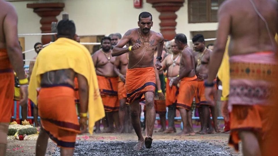 Devotees cross the fire pit at Sri Mariamman Temple during the annual fire-walking festival.   (Straits Times)