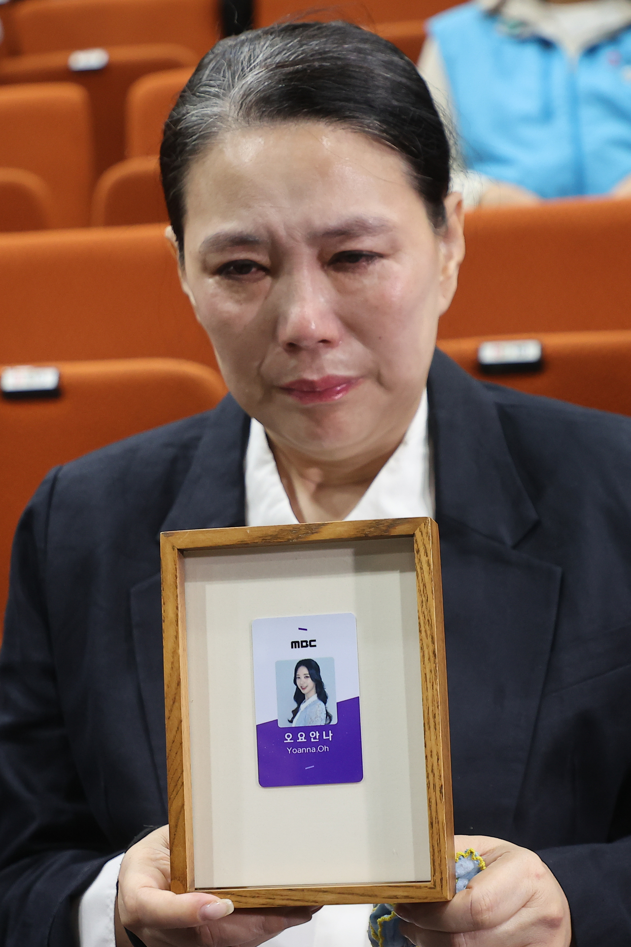 Jang Yeon-mi, mother of the late Oh Yoanna, cries holding an honorary employee certificate for her daughter during a press conference held in Sangam-dong, Seoul, Wednesday. (Yonhap)