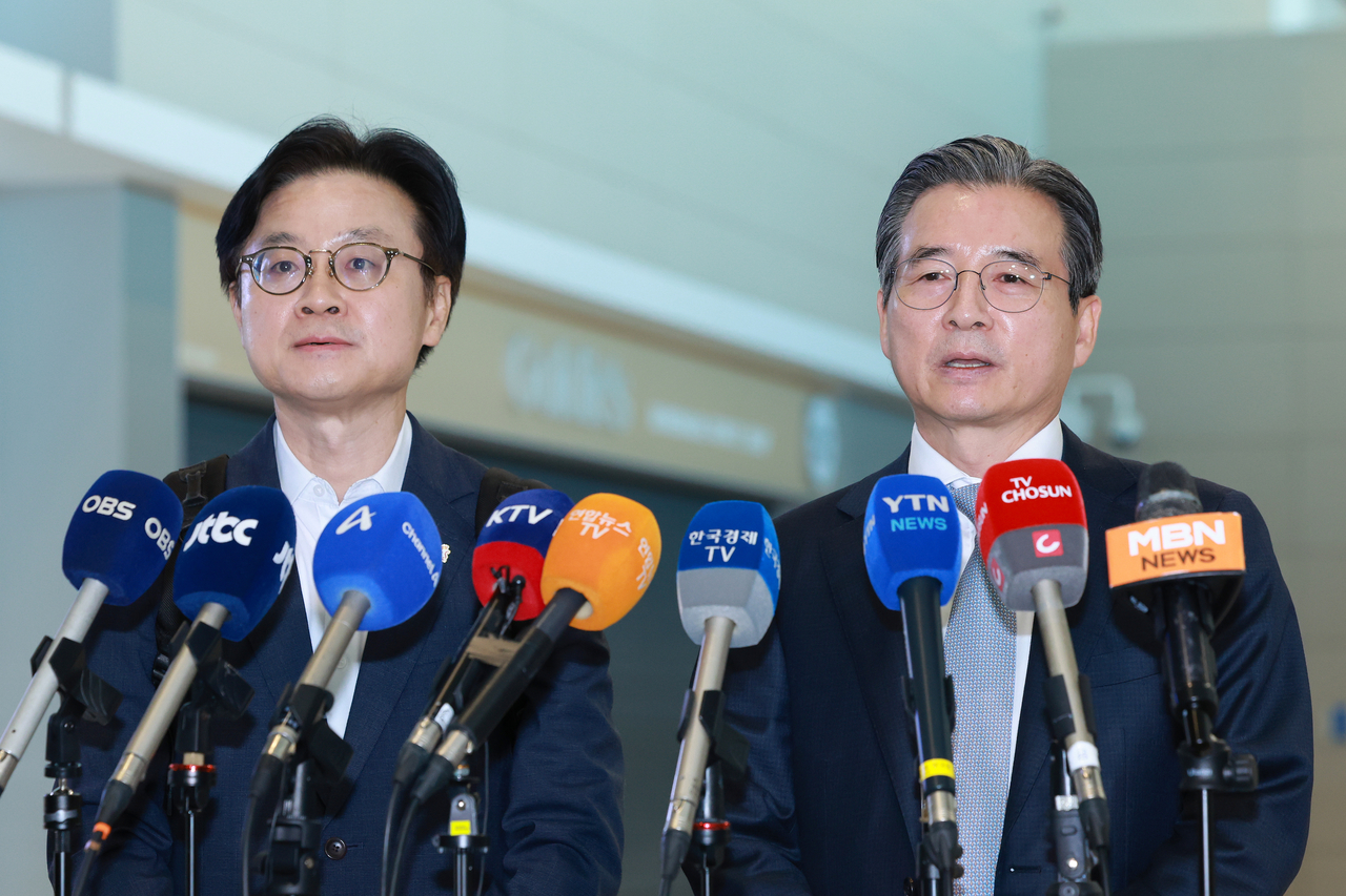 Kim Yong-beom (R), the presidential chief of staff for policy, and Industry Minister Kim Jung-kwan field questions from reporters at Incheon International Airport, west of Seoul, on Thursday, before their departure for Washington for trade talks with the United States. (Yonhap)