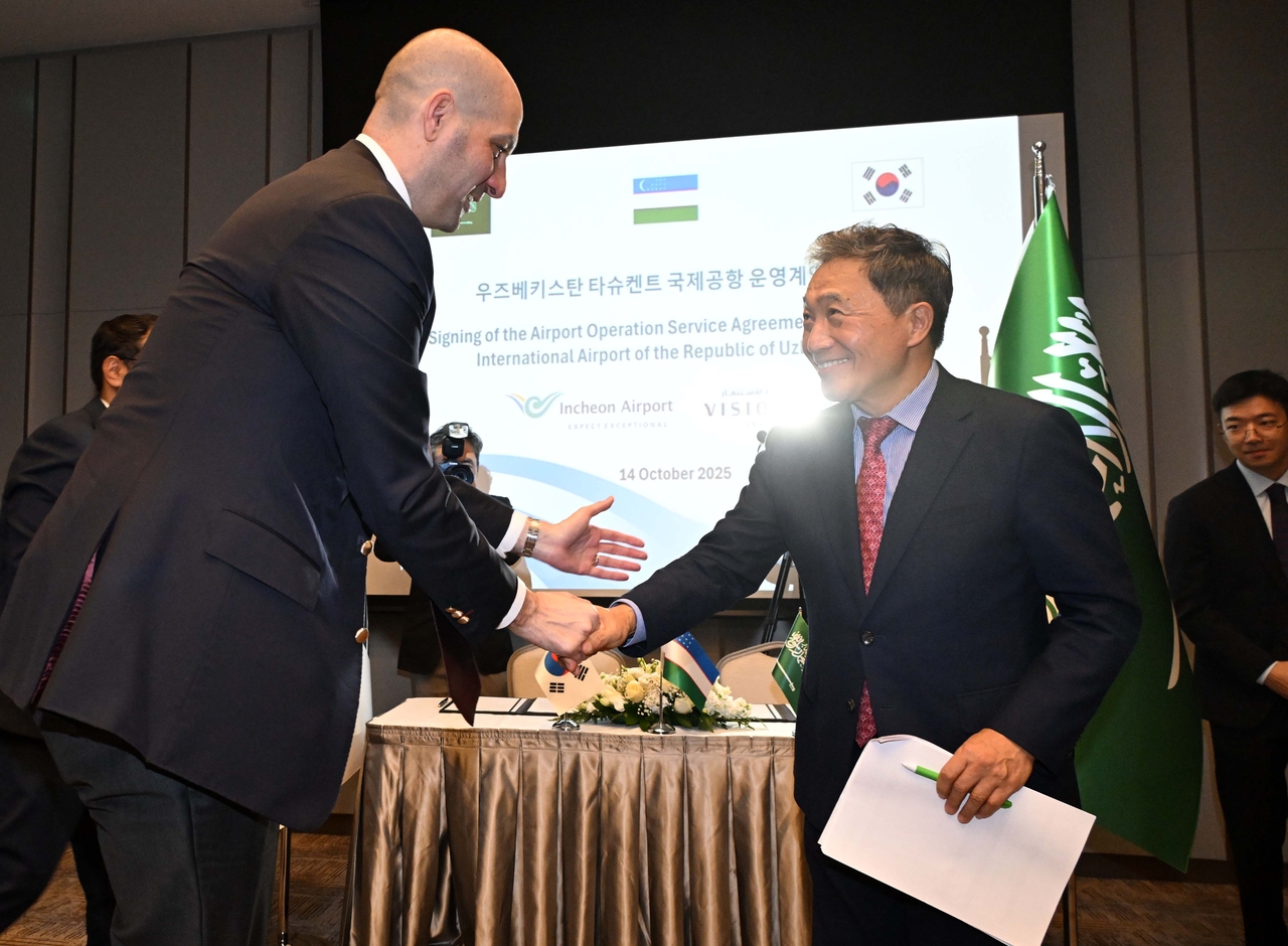 Incheon International Airport Corporation CEO Lee Hak-jae (right) shakes hands with Vision Invest CEO Omar N. Al-Midani following the signing ceremony on Tuesday in Tashkent, Uzbekistan. (Incheon International Airport Corporation)