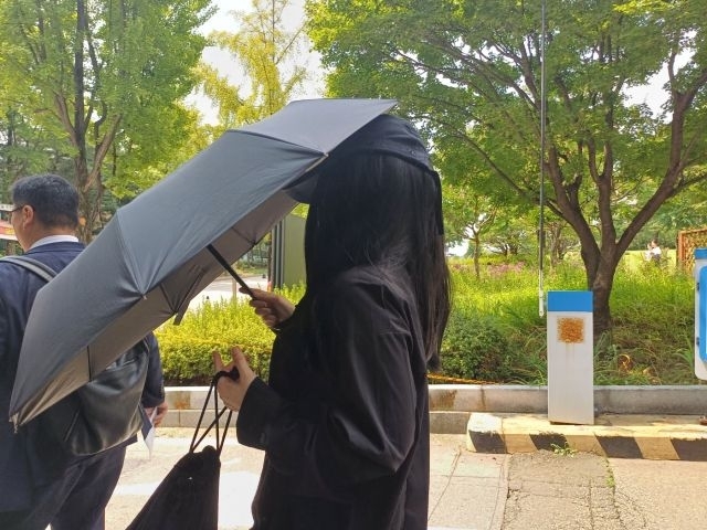 Park, the operator of the YouTube channel “De-fandom Camp,” who has been indicted on charges of defaming singer Kang Daniel, leaves the courtroom with her attorney after attending a final hearing at the Seoul Central District Court in Seocho District, southern Seoul, in August last year. (Yonhap)
