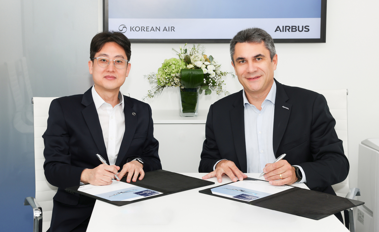 Korean Air’s head of predictive maintenance Oh Jong-hoon (left) and Airbus’ head of digital services business Fabrice Villaume sign a partnership agreement in London on Thursday. (Korean Air)