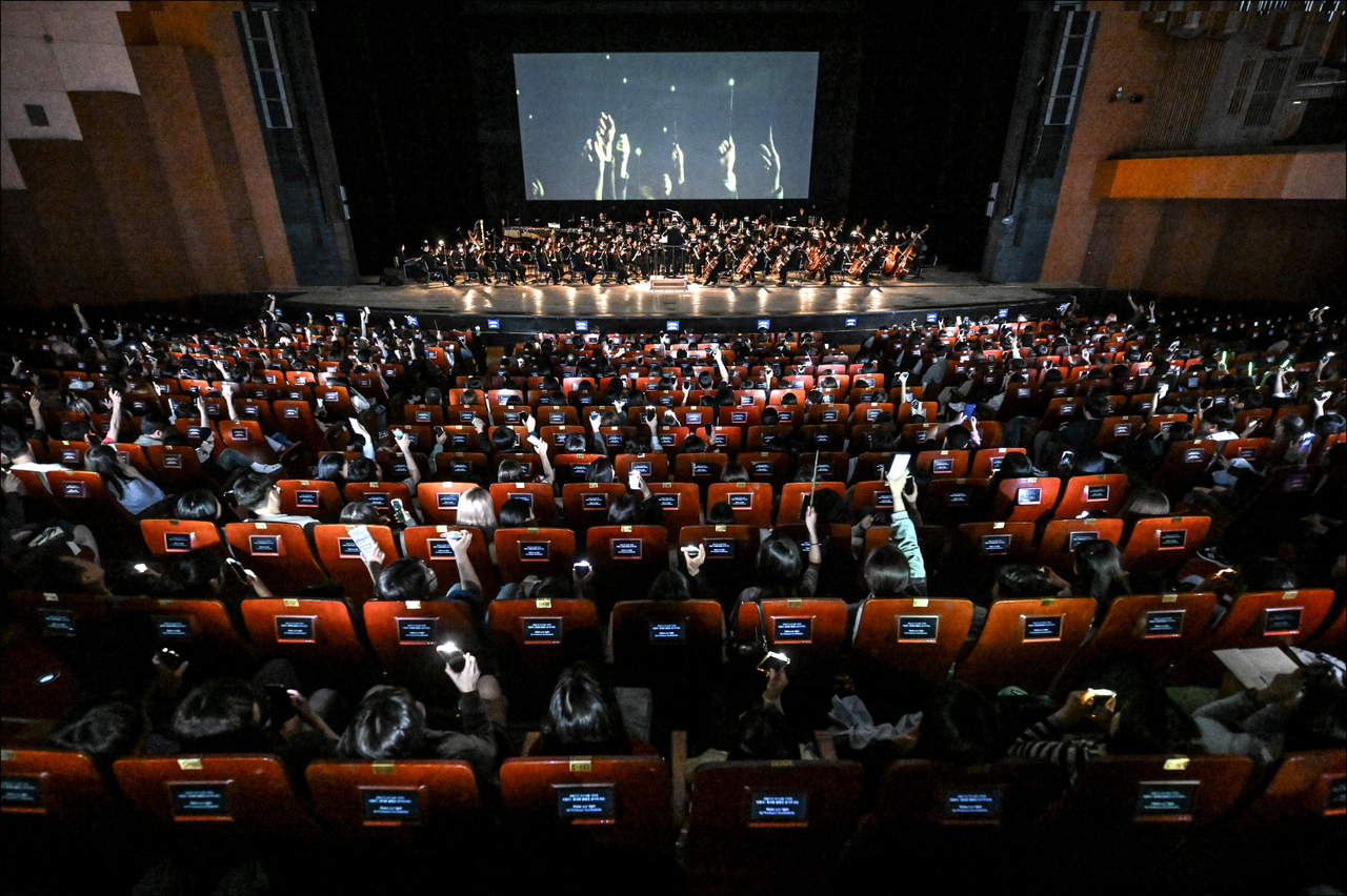 Audience members shine their lights and join in during a participatory section of the "Harry Potter and the Half-Blood Prince in Concert," in May at the Sejong Center in Seoul. (Sejong Center for Performing Arts)