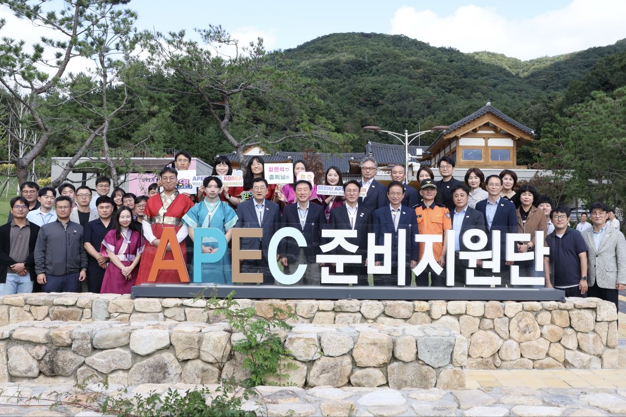 Prime Minister Kim Min-seok (fromt, fifth from left) poses for a photo with on-site staff of the APEC preparation and support team in Gyeongju, North Gyeongsang Province, on Oct. 10. (Prime Minister’s Office)