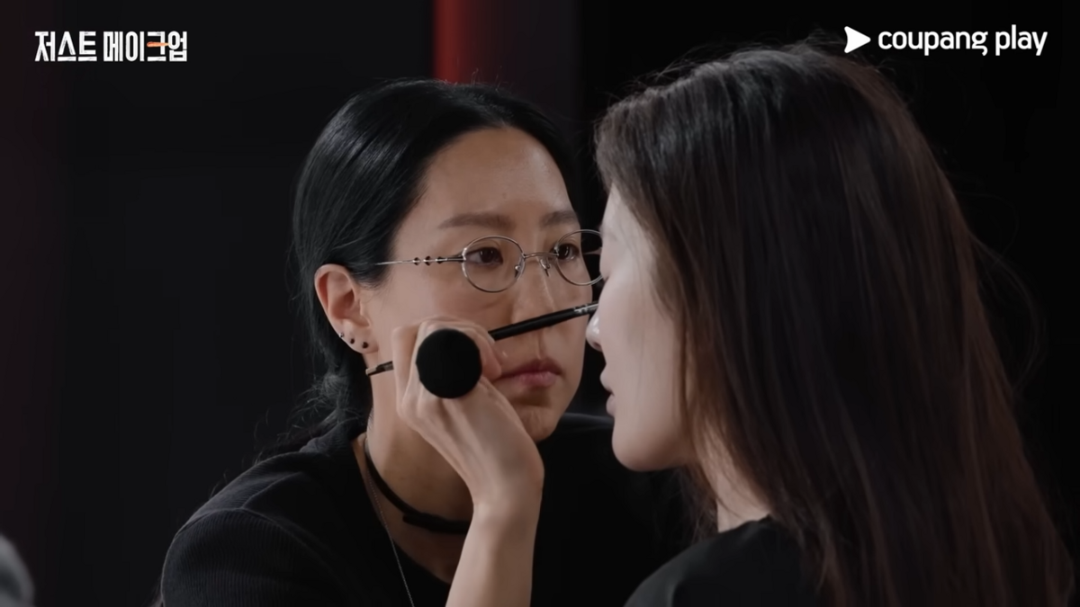 Makeup artist Son Joo-hee (left) works on a participant in "Just Makeup" (Coupang Play)