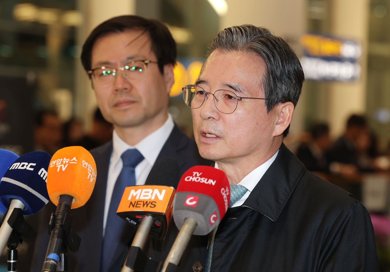 Kim Yong-beom (right), director of national policy at the presidential office, speaks to reporters at the Incheon Airport on Sunday, (Yonhap)
