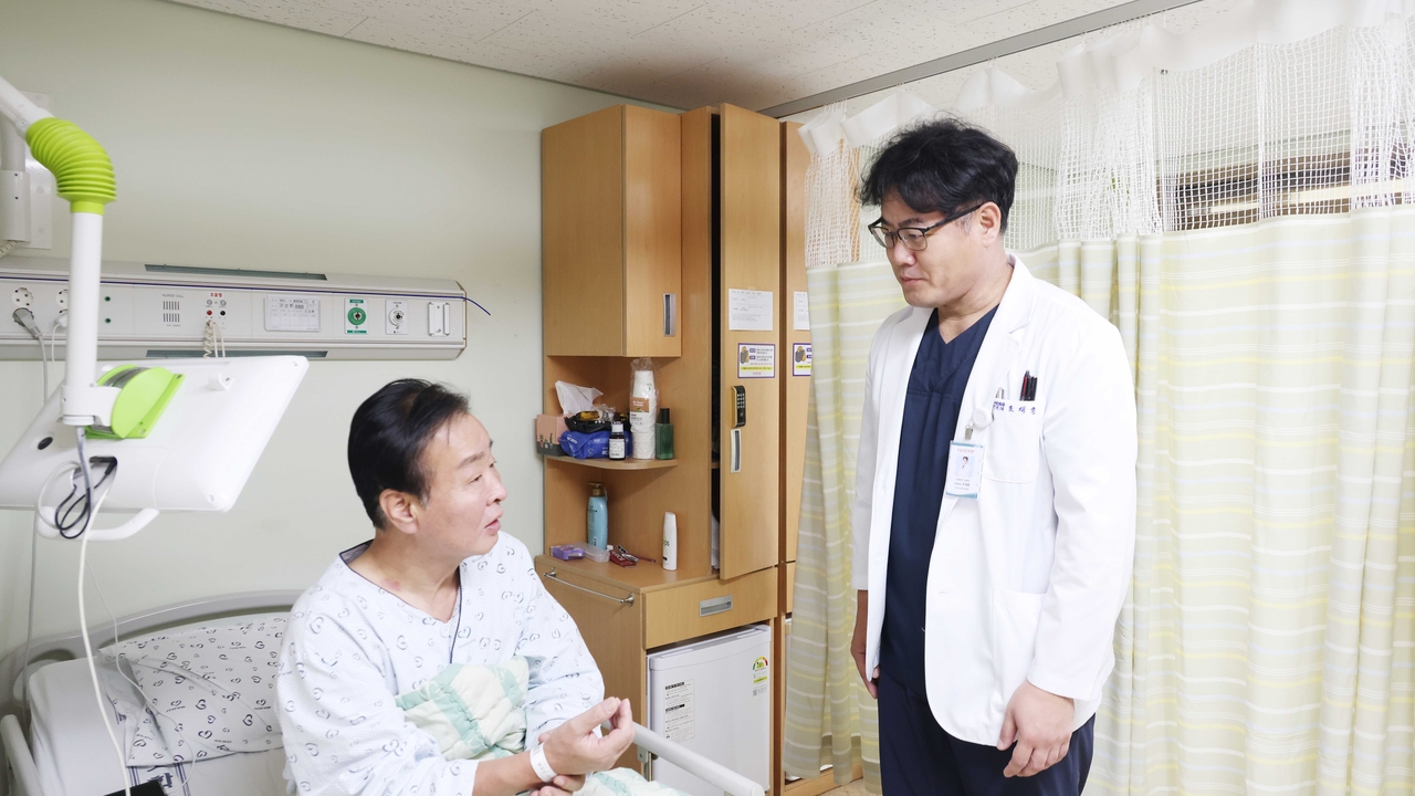 포항세명기독병원 지역심뇌혈관질환센터 조재훈 부장(사진 오른쪽)이 뇌경색 진단 후 혈전제거술을 받고 후유증 없이 회복 중인 A씨를 회진하고 있는 모습[포항세명기독병원제공]