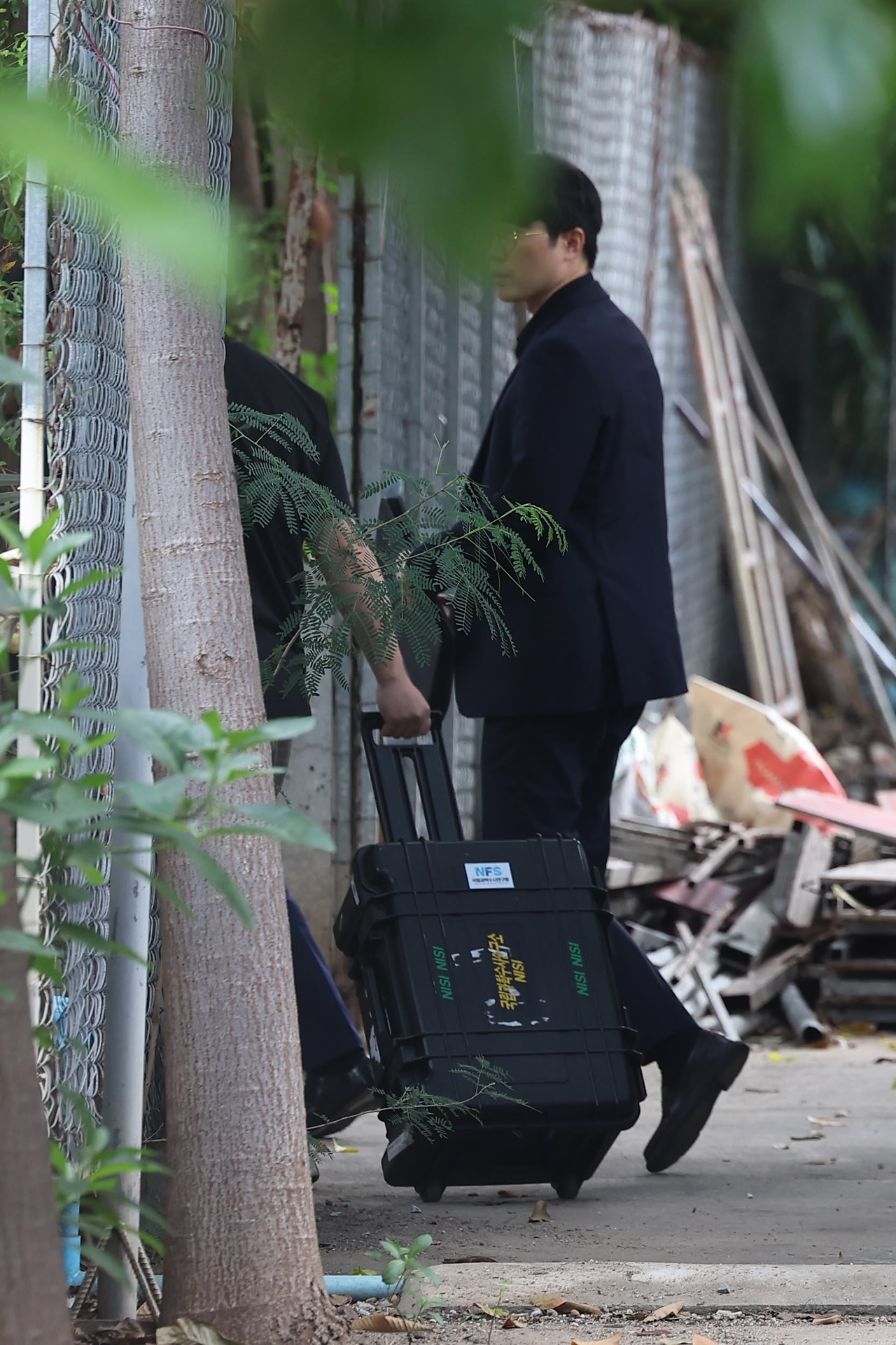 A South Korean forensic team member transports equipment into the morgue area at Tuktla Temple in Phnom Penh on Monday as preparations for the autopsy get underway. (Yonhap)