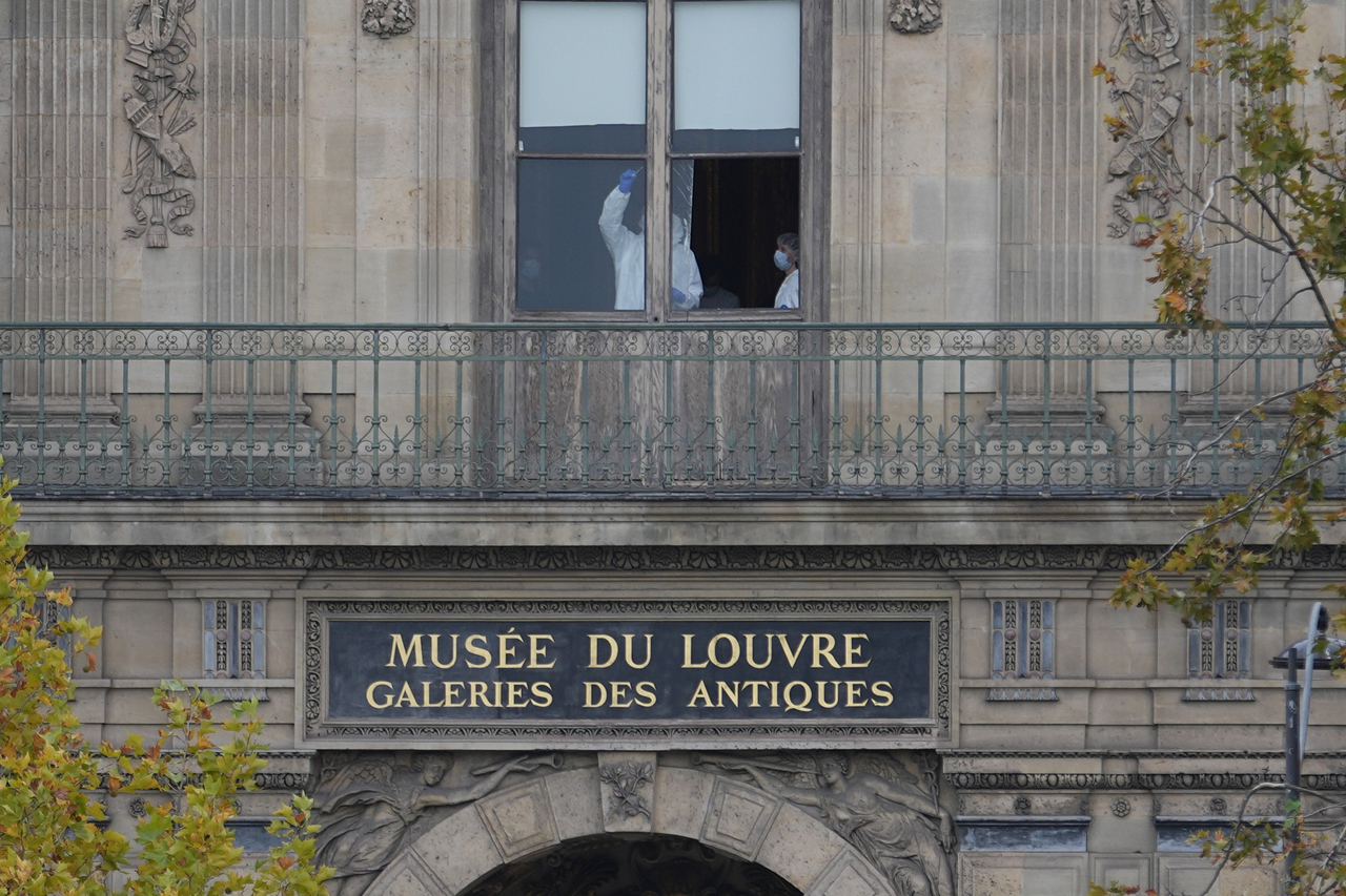 Police officers work inside the Louvre museum in Paris on Sunday.   AP-Yonhap