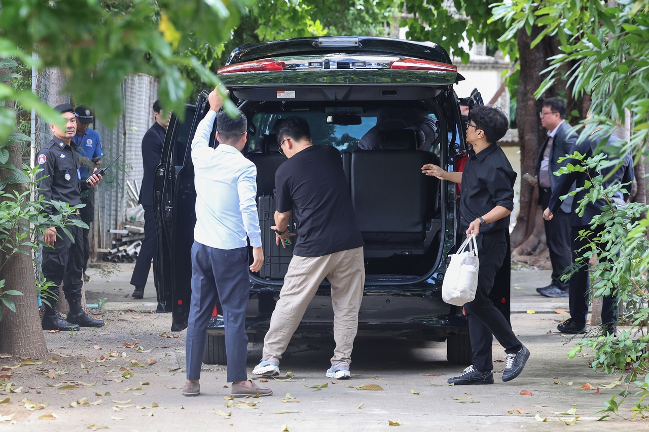 South Korean forensic officials unload equipment from a vehicle at Tuktla Temple in Phnom Penh on Sunday morning as they prepare to begin on-site procedures. (Yonhap)