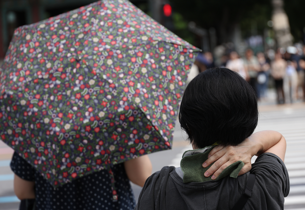 A person wipes away sweat in Gwanghwamun, Seoul, on Sept. 5. (Yonhap)