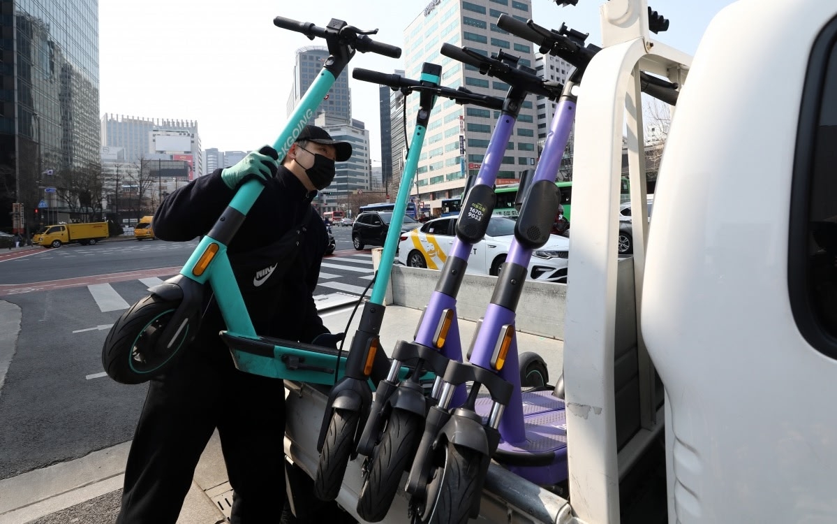 A personal mobility towing contractor retrieves e-scooters near Seoul Plaza in central Seoul in March. (Newsis)