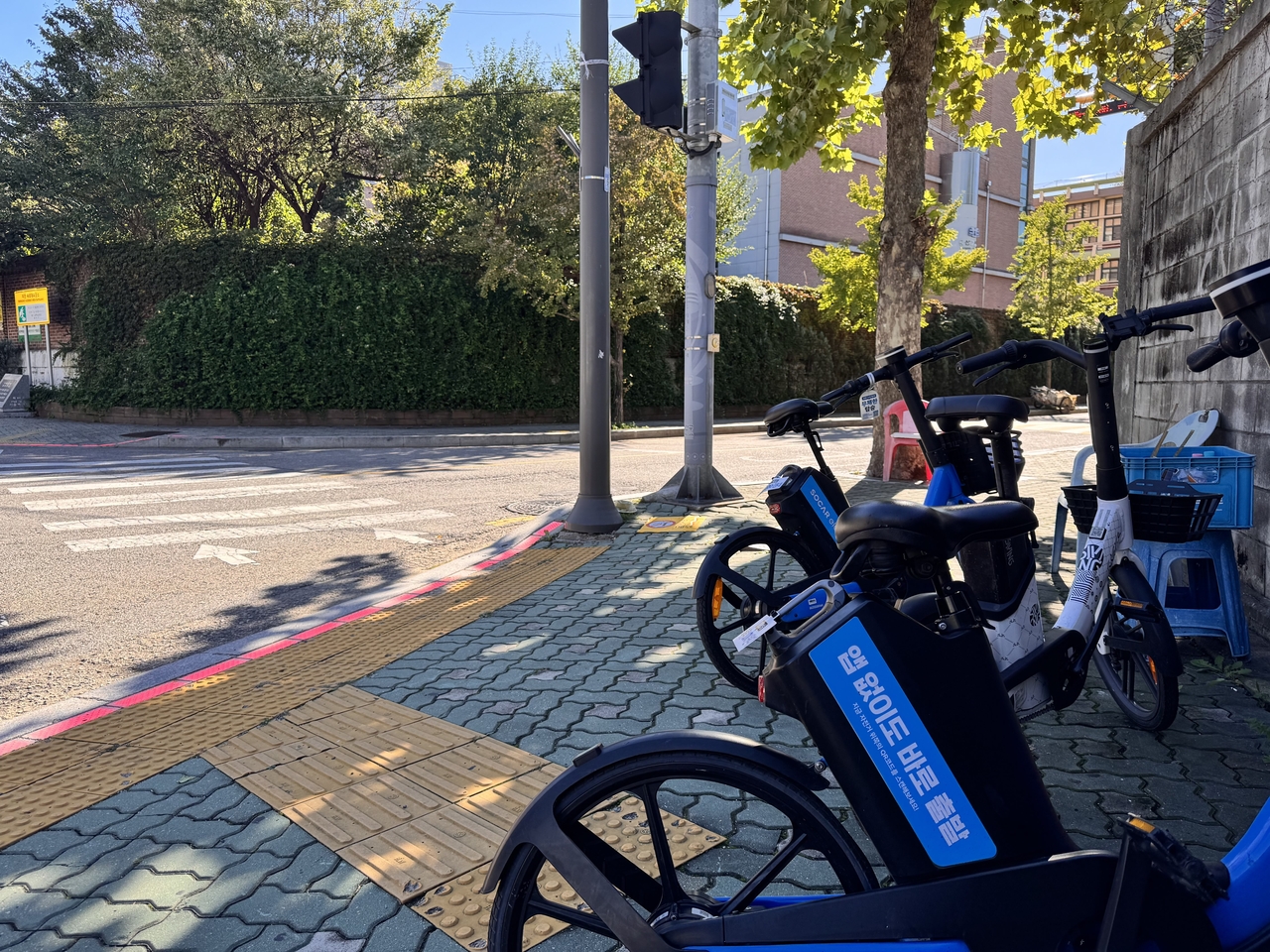 Shared e-bikes from multiple operators are parked near a crosswalk in Seoul’s Yongsan District in October, in an area where e-scooters would have been towed under city rules. (Moon Joon-hyun/The Korea Herald)