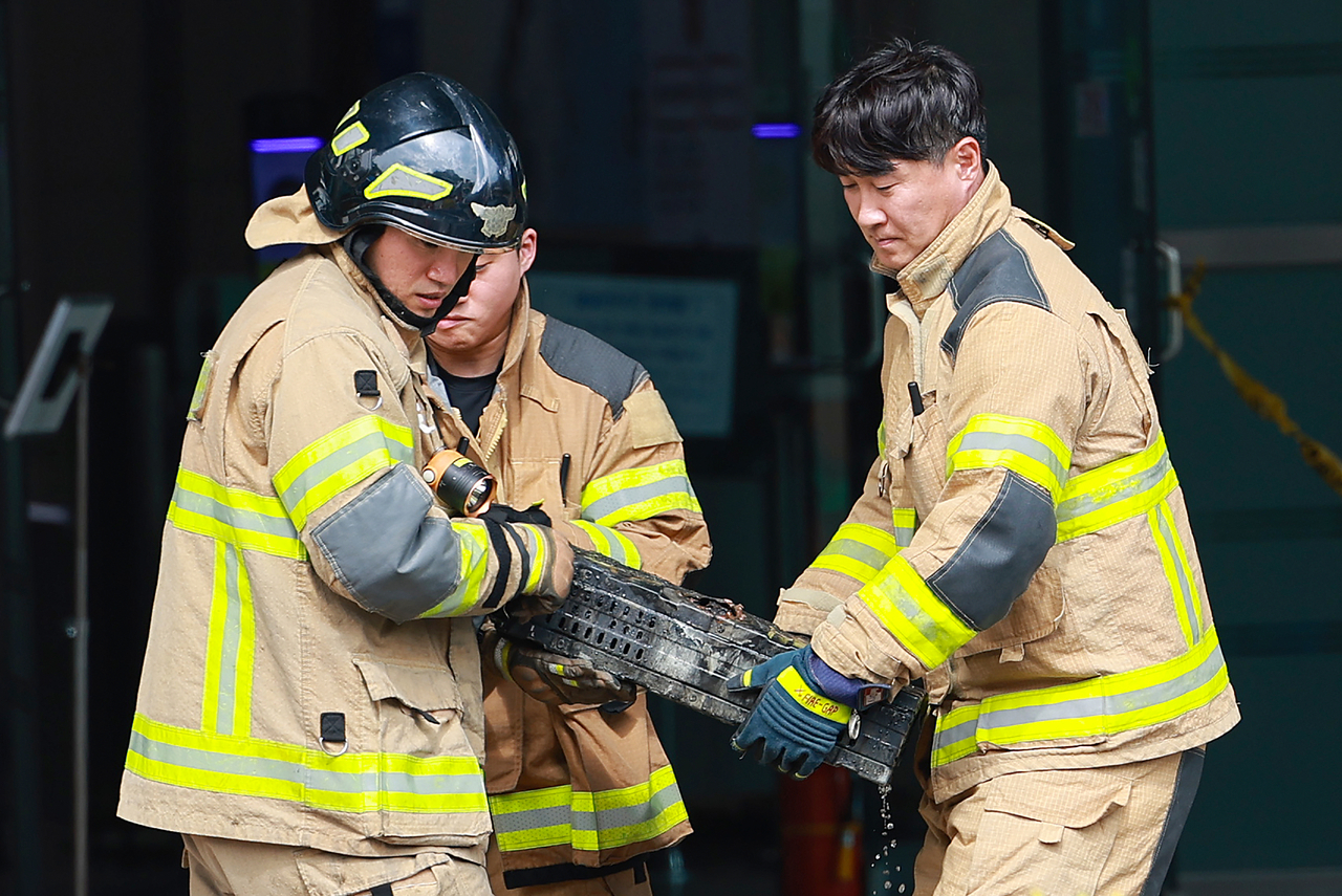Firefighters move a lithium-ion battery burned in a fire at the National Information Resources Service in Daejeon on Saturday. (Yonhap)