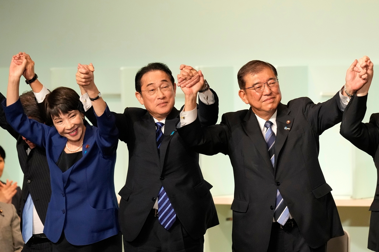 Former Prime Minister Shigeru Ishiba (right) celebrates with new Prime Minister Sanae Takaichi (left) and then-Prime Minister Fumio Kishida (center) after Ishiba was elected as the new head of Japan's ruling party at the Liberal Democratic Party's leadership election, Sept. 27, 2024, in Tokyo. (Pool Photo via AP)