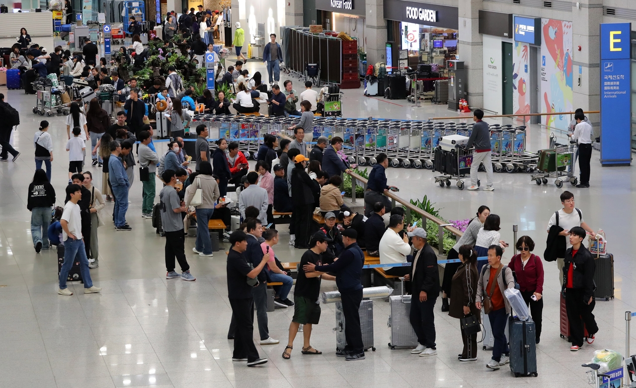 Passengers crowd the arrivals hall at Incheon Airport’s Terminal 1 on Oct. 10, following the end of a seven-day Chuseok holiday. Although the day was not a national holiday, many travelers extended their break by taking leave to create a rare 10-day vacation. (Newsis)