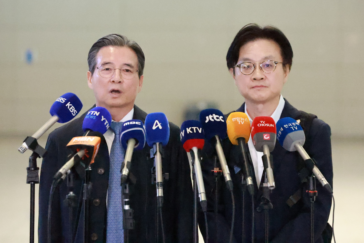 Kim Yong-beom (L), the presidential chief of staff for policy, and Industry Minister Kim Jung-kwan answer questions from reporters at Incheon International Airport, west of Seoul, on Wednesday, before their departure for Washington for trade talks with the United States. (Yonhap)