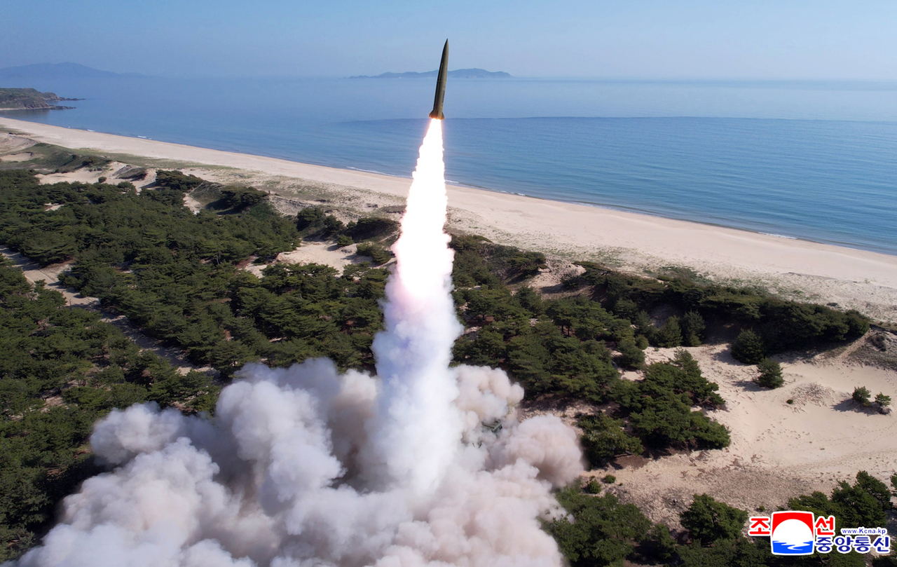 This file photo shows North Korean forces conducting a joint strike drill involving long-range artillery and a new variant of tactical ballistic missiles on the east coast on May 8. (KCNA via Yonhap)