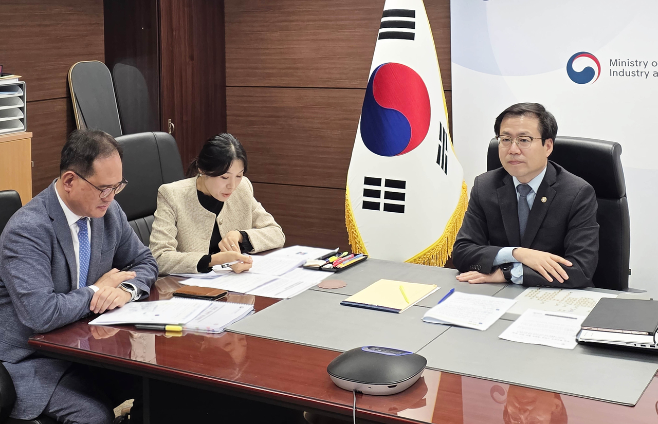 This photo provided by the Ministry of Trade, Industry and Resources shows Trade Minister Yeo Han-koo (R) holding a video meeting with China's top trade negotiator Li Chenggang on Wednesday. (Yonhap)