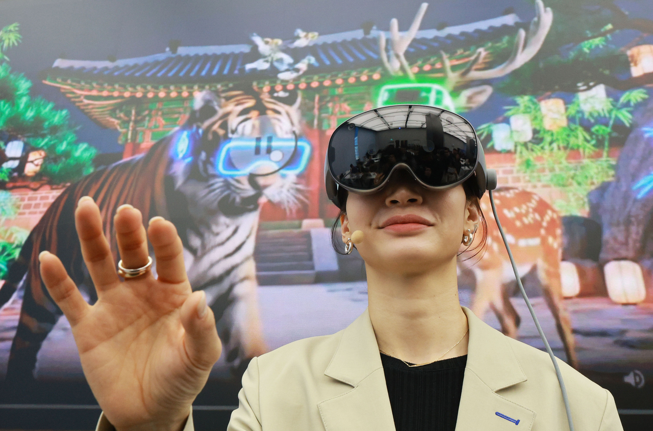 A Samsung Electronics employee demonstrates the tech giant's first XR headset at the device unveiling event held in Seoul on Wednesday. The XR headset allows users to control the device using their eyes, hands and voice. (Yonhap)
