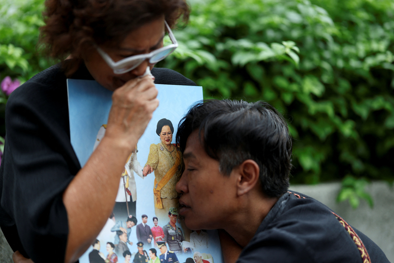 People react while holding a picture of Thailand's Queen Mother Sirikit, 93, following the announcement of her death, outside King Chulalongkorn Memorial Hospital in Bangkok, Thailand, Saturday. (Reuters-Yonhap)