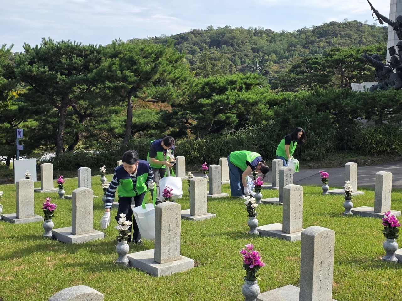 풀무원푸드앤컬처 봉사단이 국립서울현충원에서 묘역 주변 환경을 정화하는 봉사활동을 진행하고 있다. [풀무원푸드앤컬처 제공]