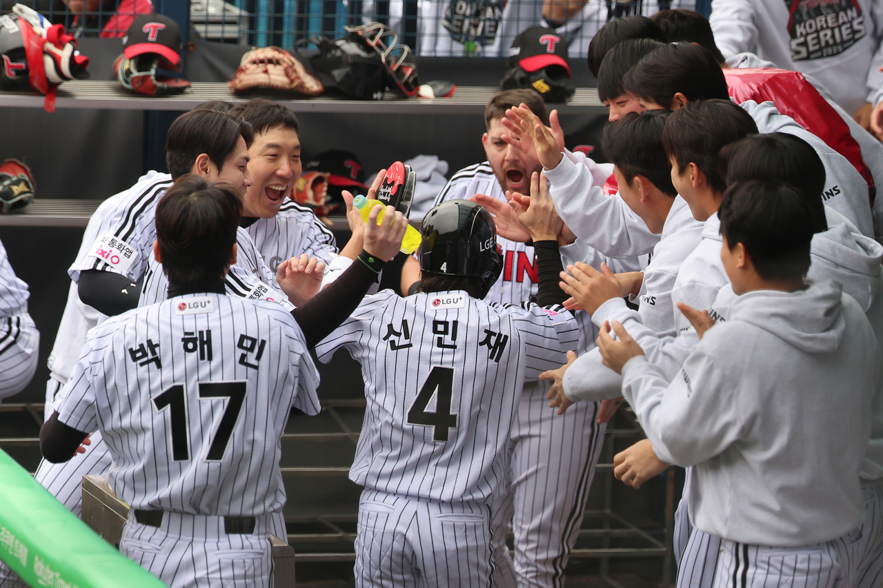 LG Twins players celebrate second baseman Shin Min-jae's run in the dugout during the Korean Series opener against Hanwha Eagles at Jamsil Stadium in Seoul on Sunday. (Yonhap)