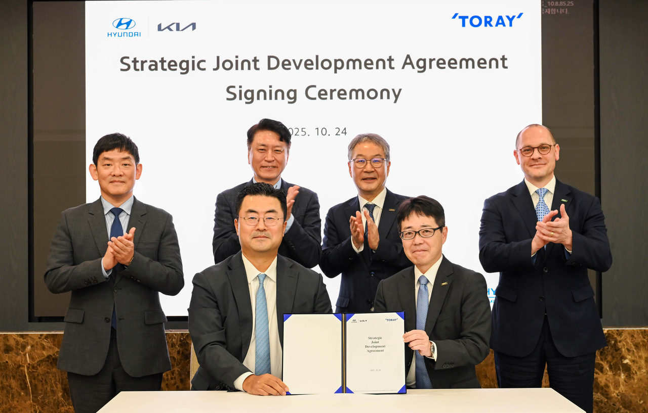 Kim Heung-soo (front, left), executive vice president and head of the Global Strategy Office at Hyundai Motor Group, and Miki Terada (front, right), general manager of the Advanced Composites Division at Toray Group, pose for a photo after signing a strategic joint development agreement at Hyundai Motor’s headquarters in southern Seoul on Friday. (Hyundai Motor Group)