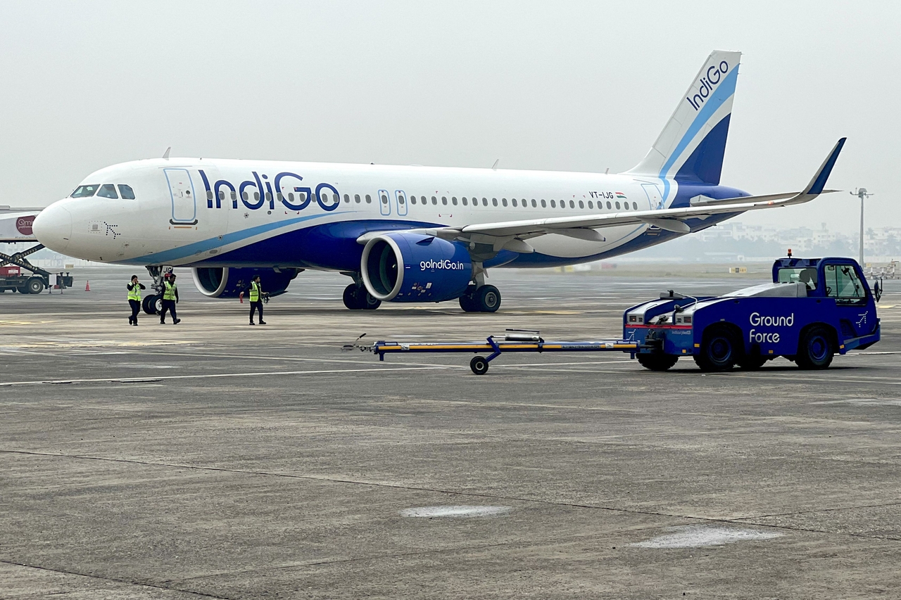 Ground staff walk past an Indigo airlines aircraft in Kolkata, India, in 2024. (AFP-Yonhap)
