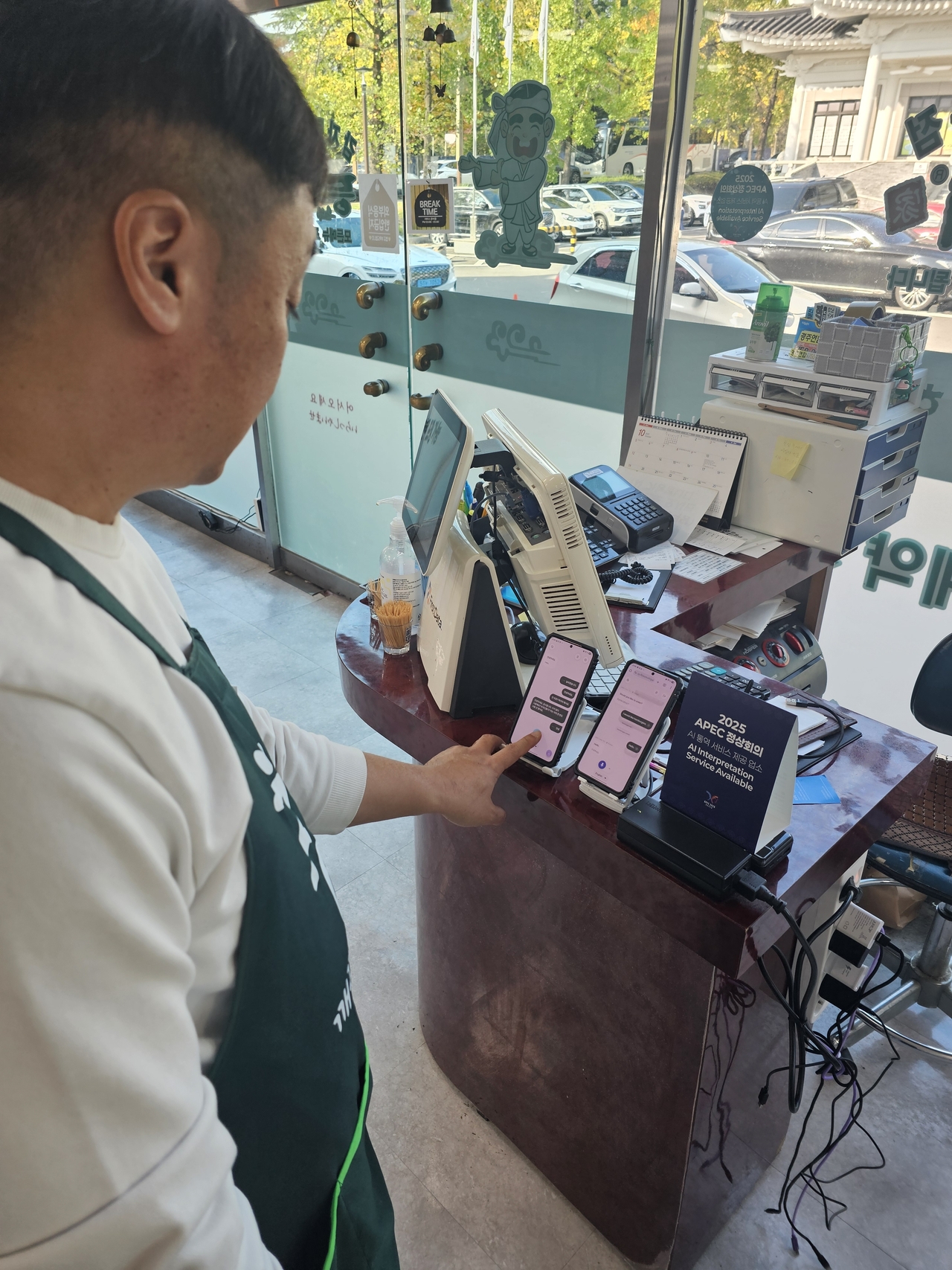 Kong demonstrates how to use the AI-based translation devices provided by the APEC Summit Preparatory Committee. (Choi Jae-hee/The Korea Herald)