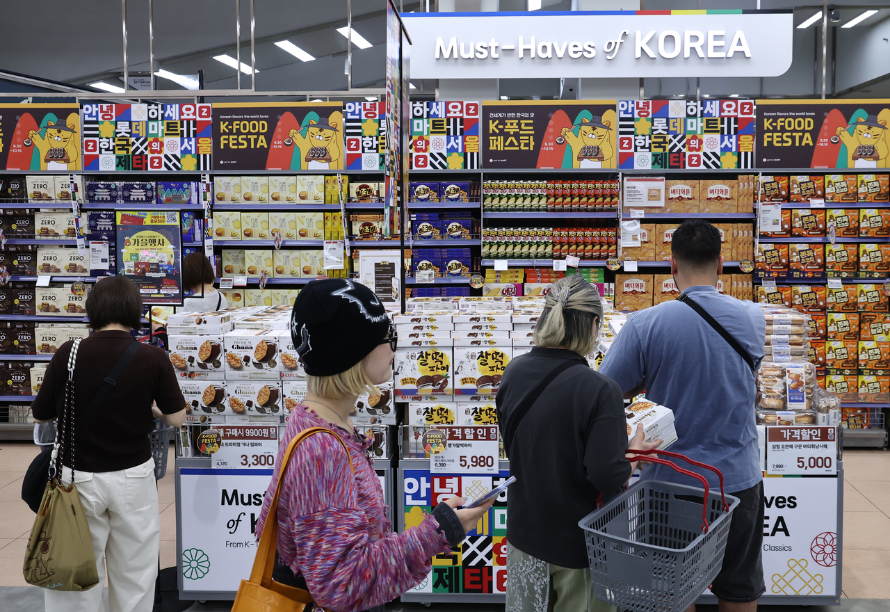 Customers pick food products displayed on the shelves at a discount store in Seoul, in this file photo taken Sept. 30. (Yonhap)