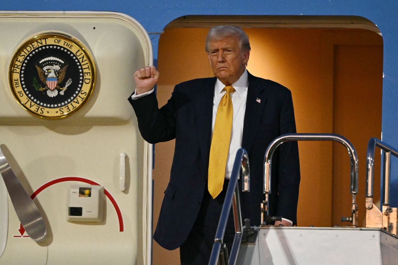 US President Donald Trump gestures as he prepares to alight from Air Force One upon arrival at Haneda Airport in Tokyo on Monday. (AFP-Yonhap)